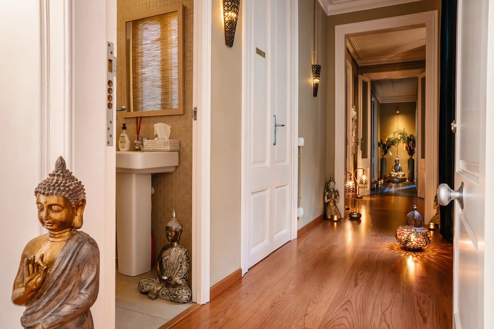 Couloir intérieur avec lavabo, Bouddhas dorés et lanternes allumées