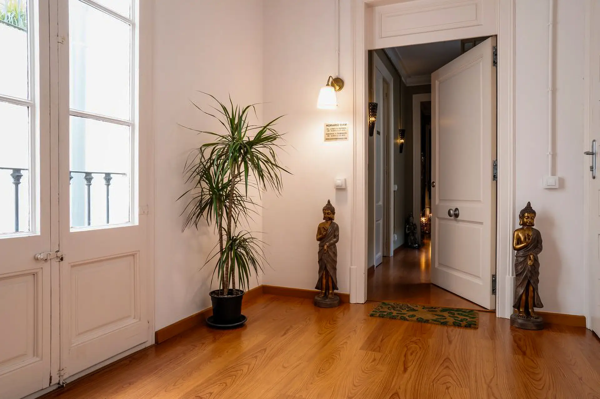 Entrée avec porte ouverte, plante et statues de Bouddha